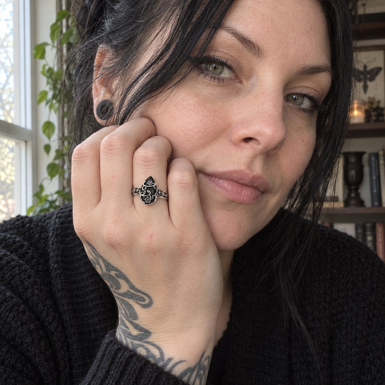 Window-lit portrait with the black-stone floral ring worn beside the face