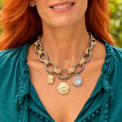 Mixed-tone twisted links and three charms worn with a teal blouse