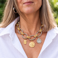 Close view of mixed-tone necklace worn with an open white collar
