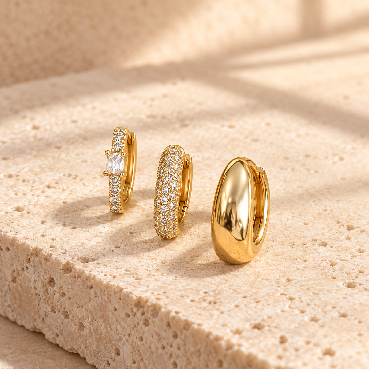 Gold Tone three-piece chunky hoop earring stack on ivory stone