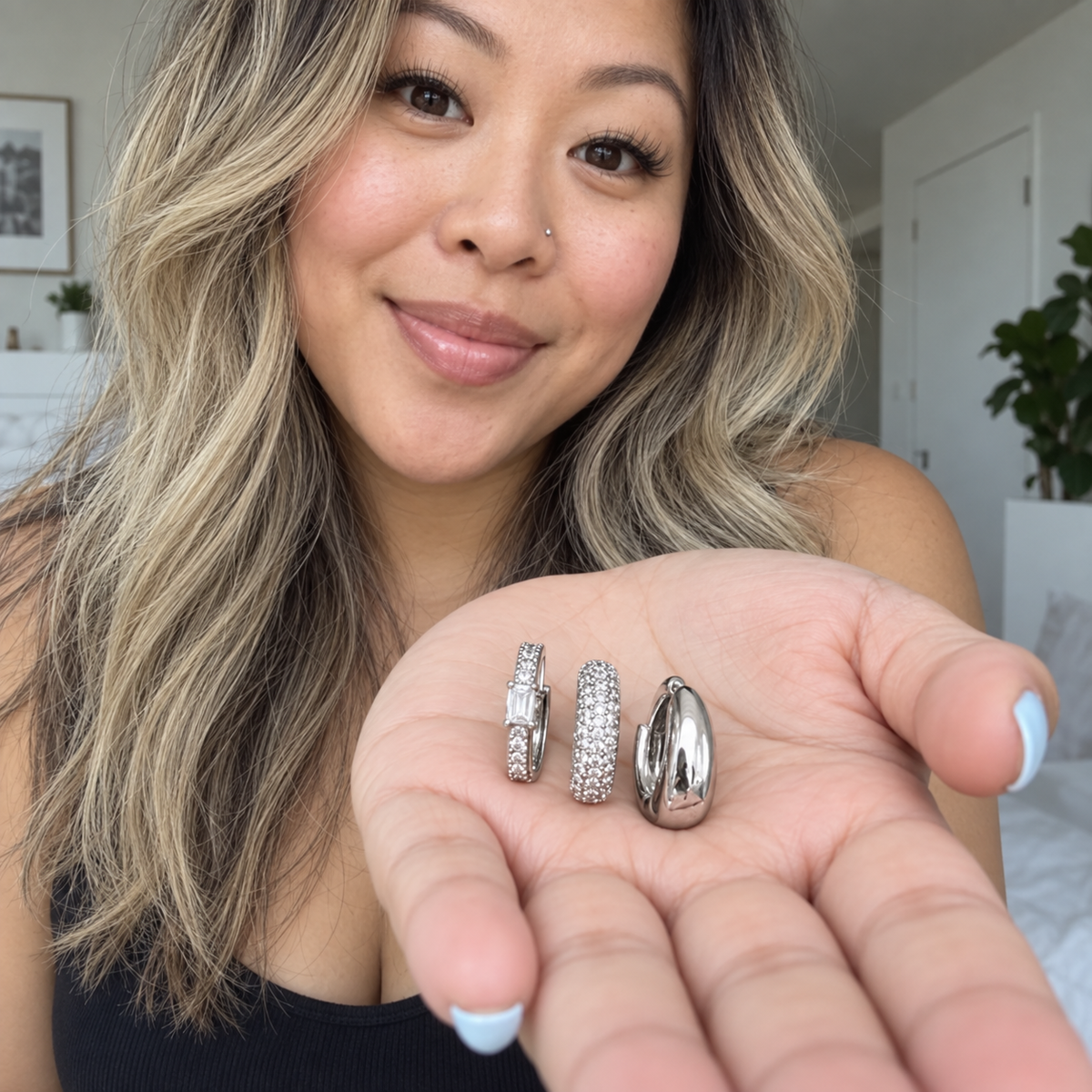 Woman holding the three Silver Tone earrings in her palm