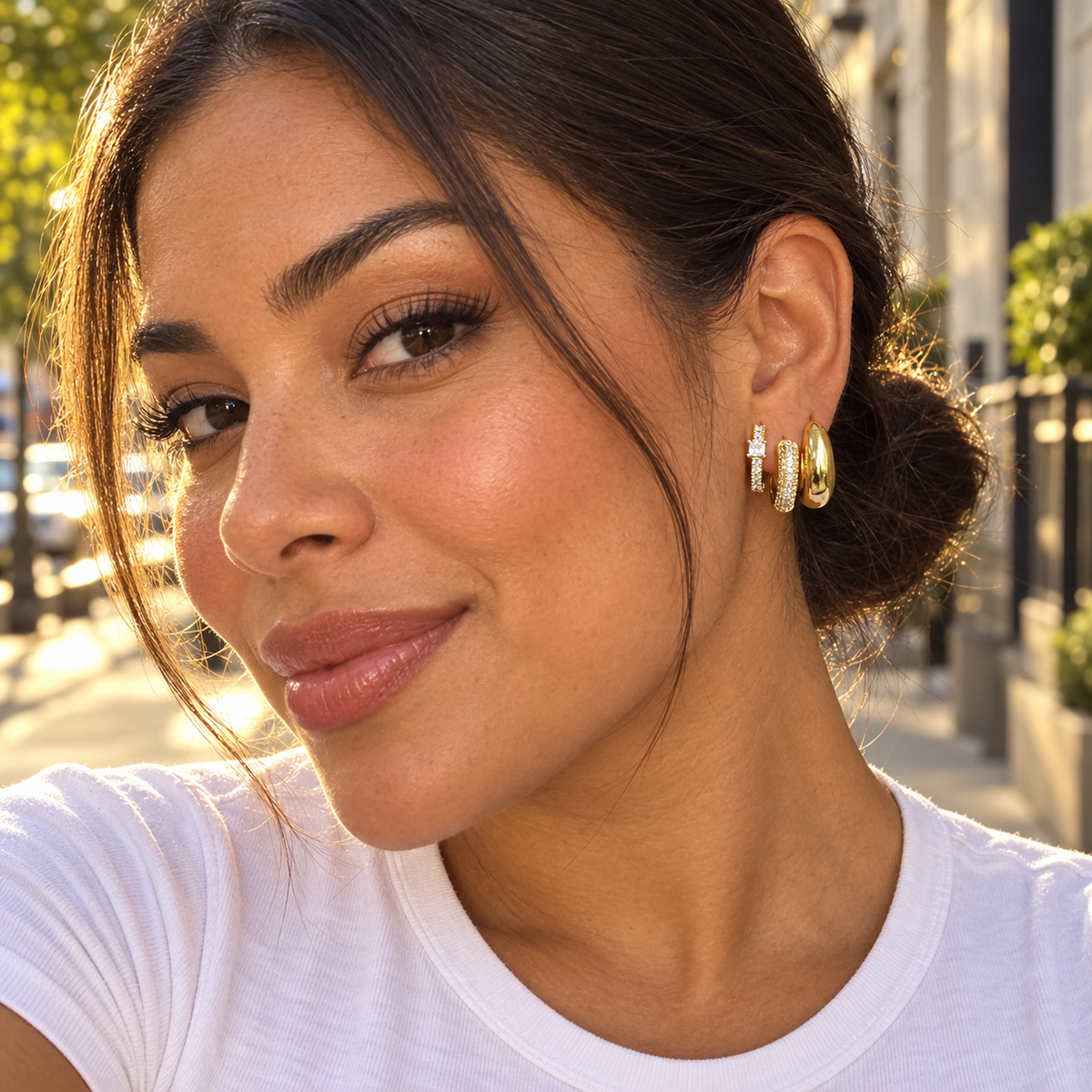 Woman wearing the Gold Tone earring stack outdoors at golden hour