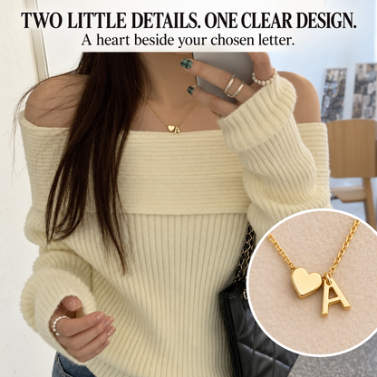 Heart and initial necklace styled with a cream knit top