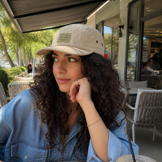 Woman styling the lightweight cap at a cafe patio