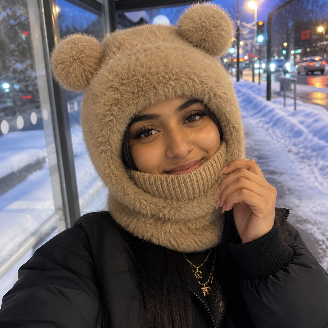 South Asian woman styling the brown Teddy Bear Balaclava at a snowy bus stop