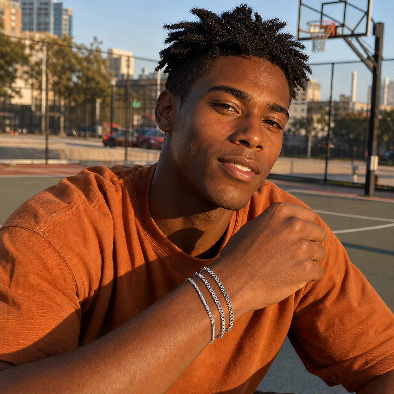 Man in a burnt-orange shirt wearing the Veyron three-piece silver-tone bracelet set on an outdoor basketball court