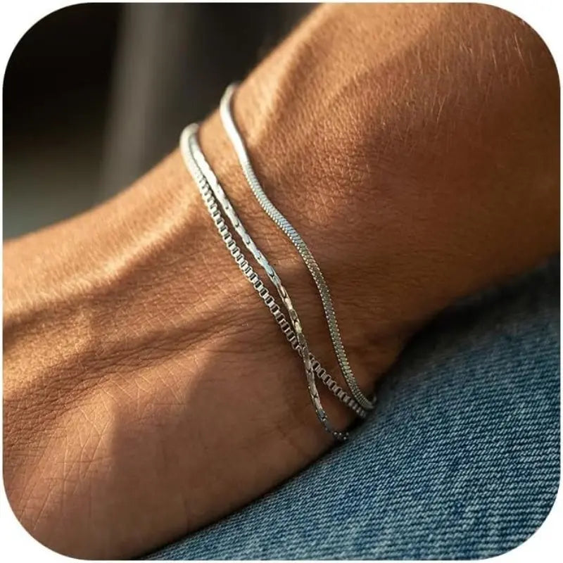 Close view of the Veyron three-chain silver-tone bracelet stack on a wrist